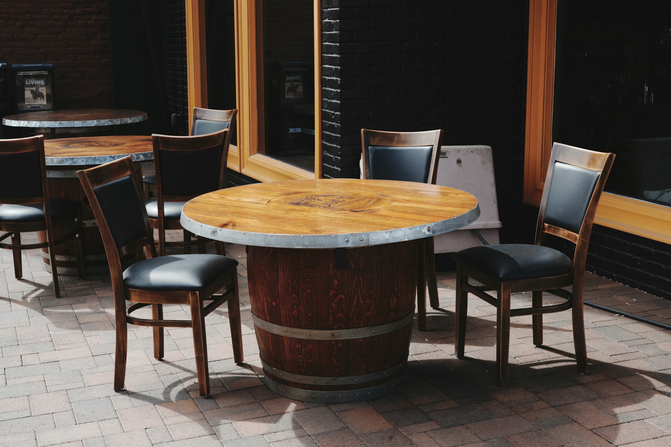 Outdoor restaurant patio with dining tables, chairs, and warm hospitality details.